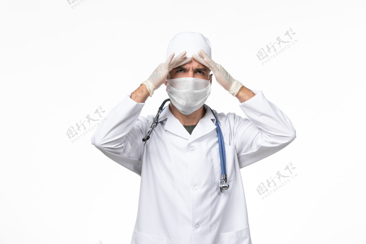 灯光正面图：男医生 穿着防毒服 戴着防毒面具 戴着蓝色听诊器 光壁上有冠状病毒病大流行病毒病毒大流行防护