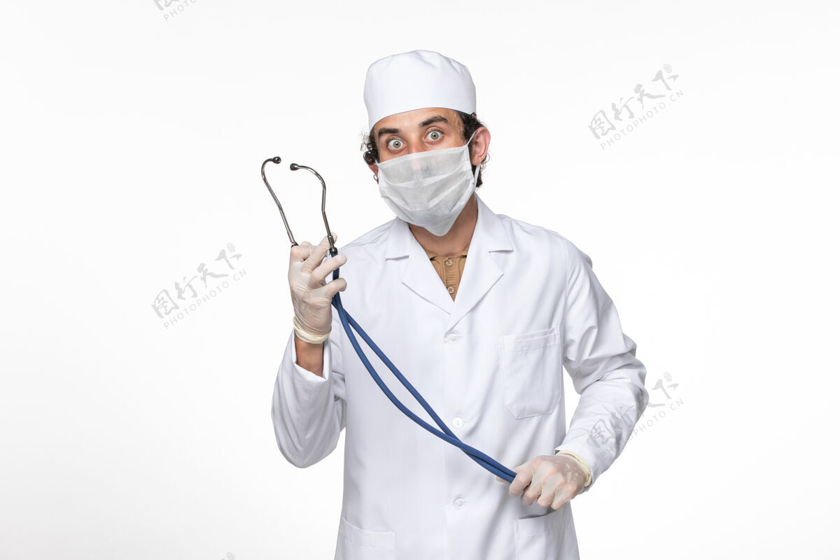 实验室外套正面图：男医生穿着医疗服 戴着口罩 以防白色桌面病毒喷溅冠状病毒大流行时戴着冠状病毒听诊器医疗听诊器防护