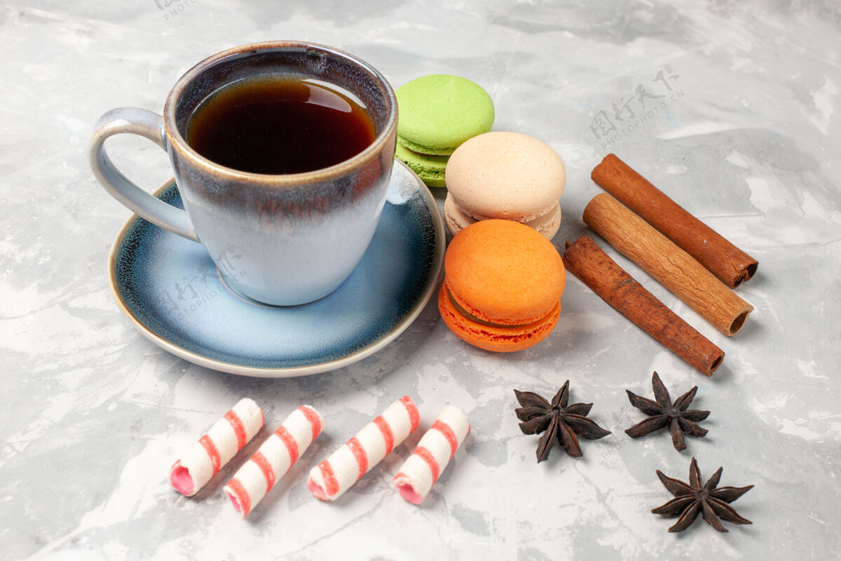 热的前视图法国麦卡龙与茶杯白色表面蛋糕饼干糖派甜饼茶碟法国茶