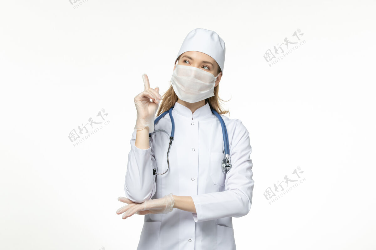 到期因冠状病毒而戴口罩的女医生正穿着医疗服思考白壁病病毒冠状病毒-大流行性疾病疾病面具医生