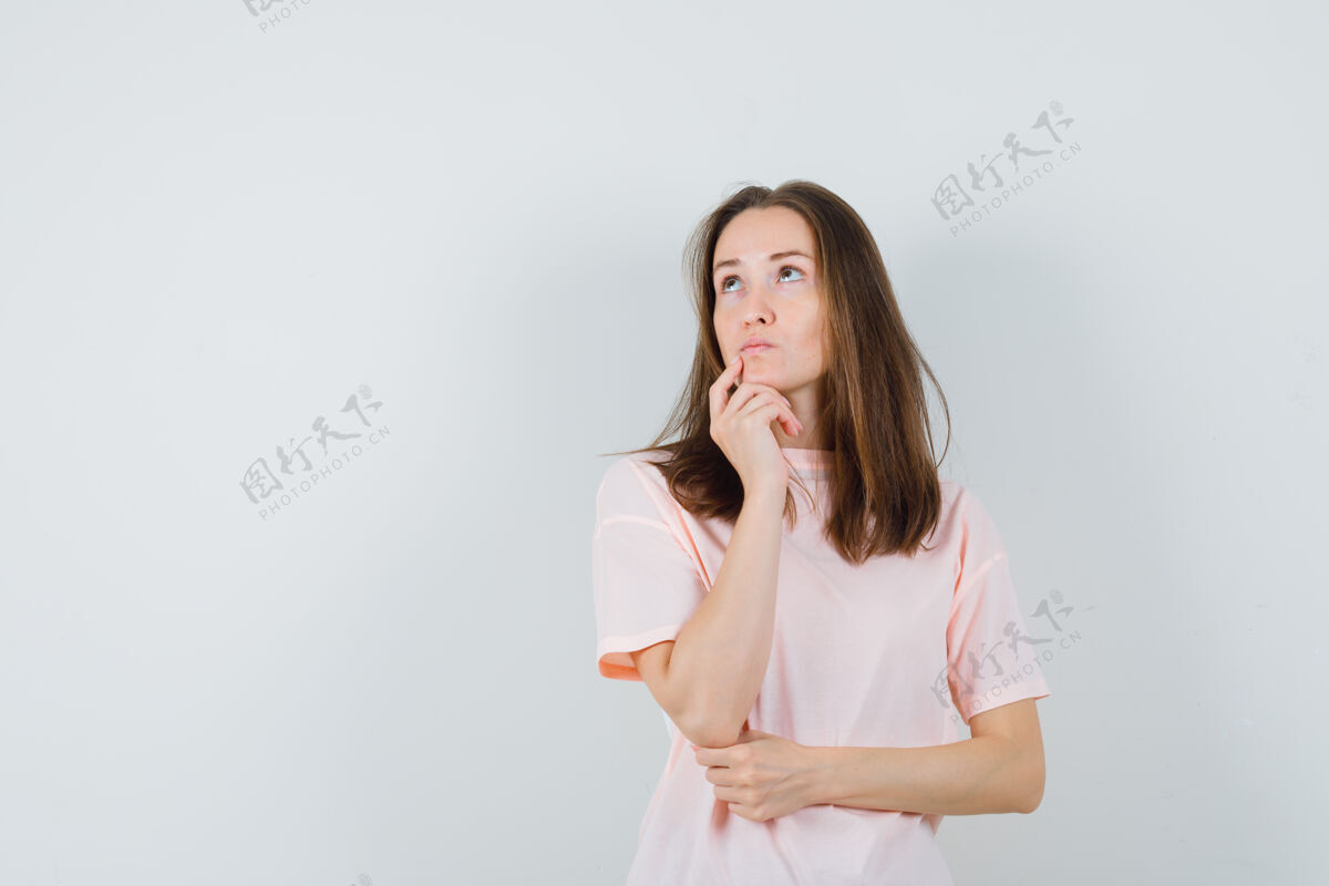 漂亮年轻女性穿着粉色t恤 手指放在下巴上 看起来犹豫不决正面图青春时尚下巴