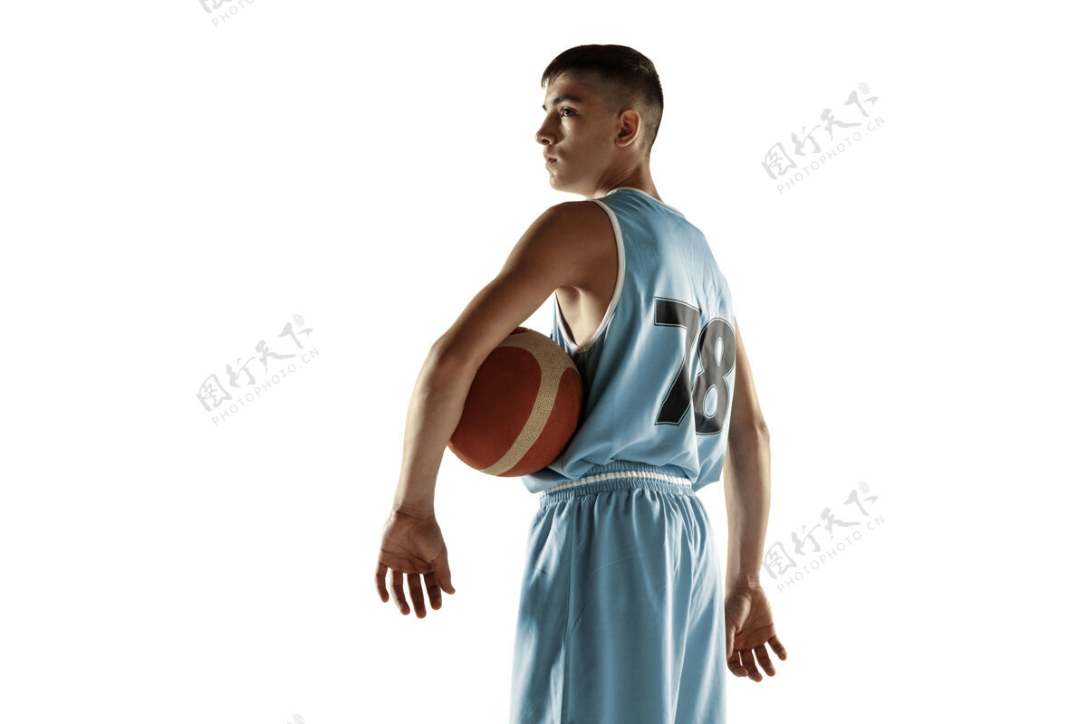 动作一个年轻的篮球运动员与一个球在空白处孤立的全长肖像男子活跃健身