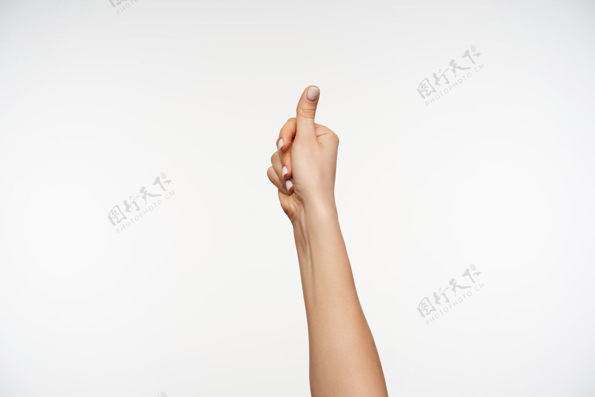 超级特写年轻的皮肤白皙的女性的手被举起 同时竖起大拇指表达举起站立