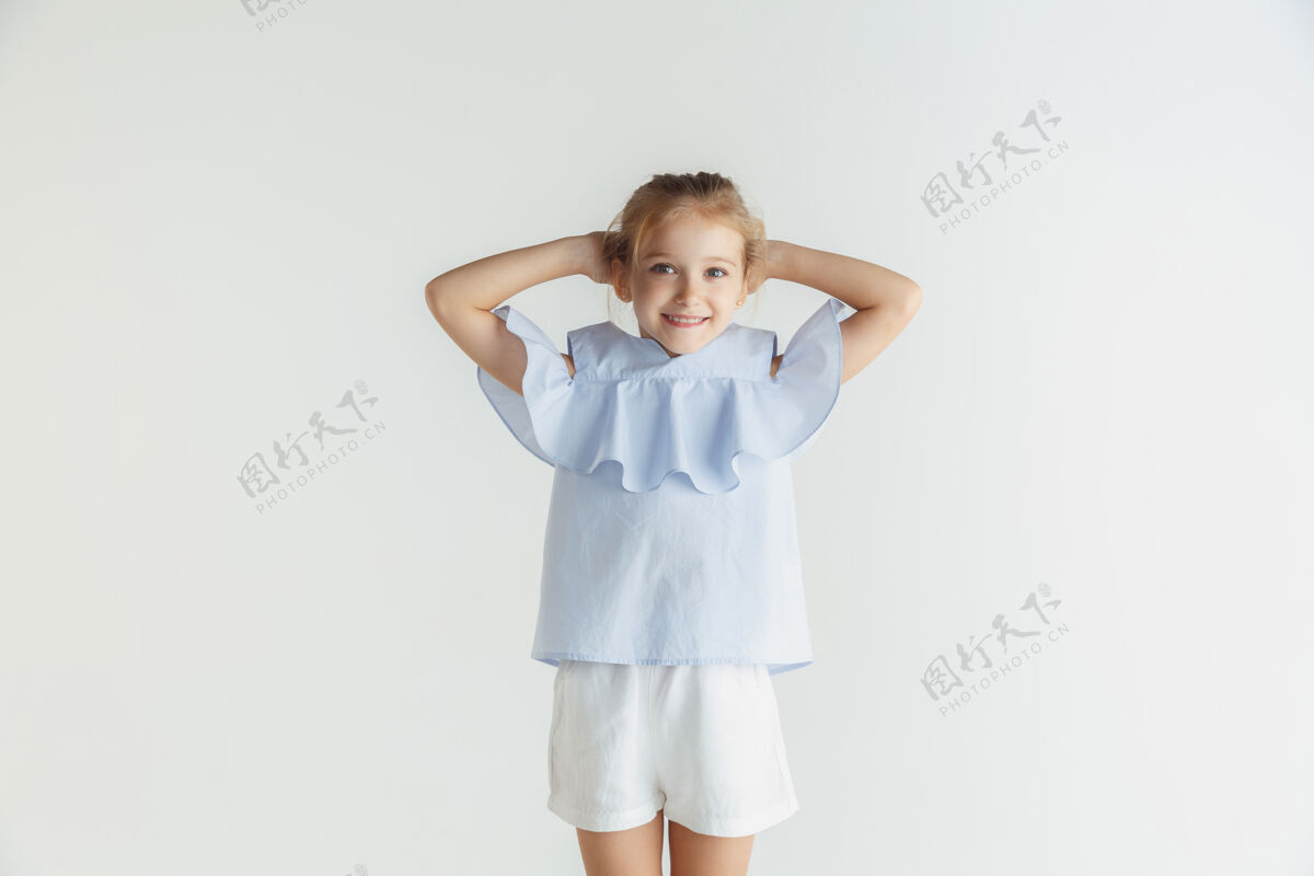 成功时尚微笑的小女孩穿着休闲服在白色空间里摆姿势白人金发女模特人类情感 面部表情 童年 销售自信小小学生
