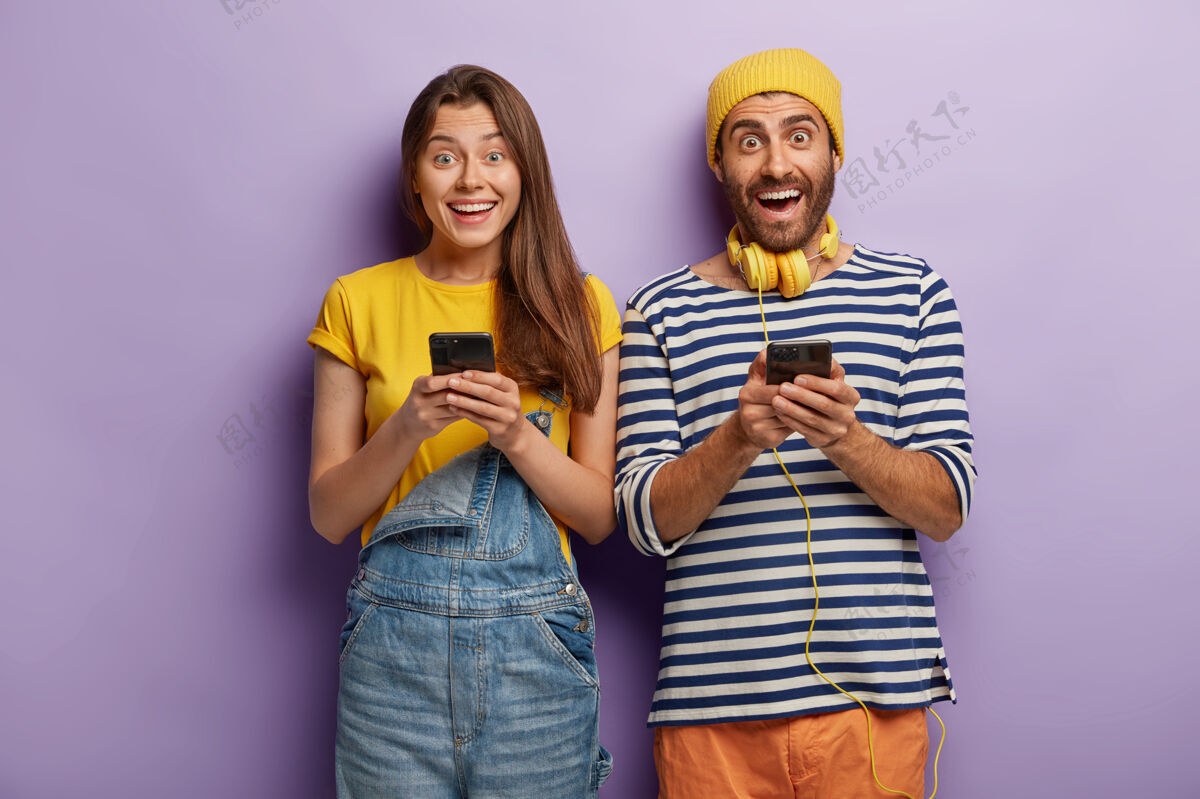 手机快乐喜出望外的年轻人发短信 沉迷于现代科技在一起电话年轻