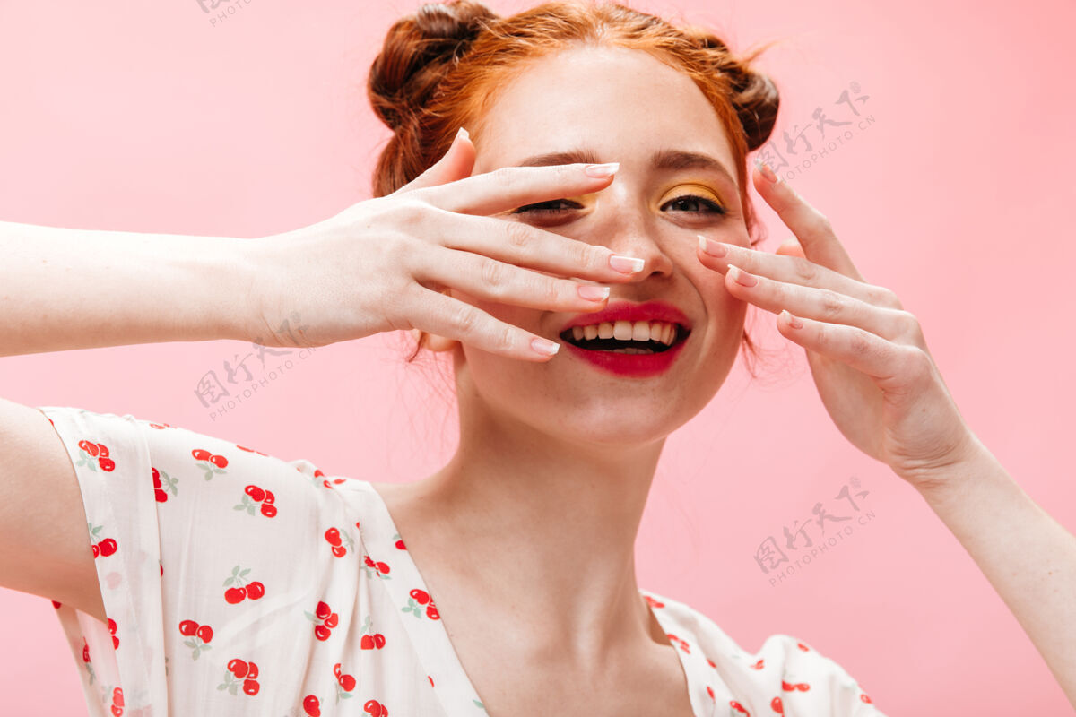 女士迷人的红发女人用手捂住脸在孤立的背景上拍摄一个有着粉红色嘴唇的绿眼睛女人女人可爱长
