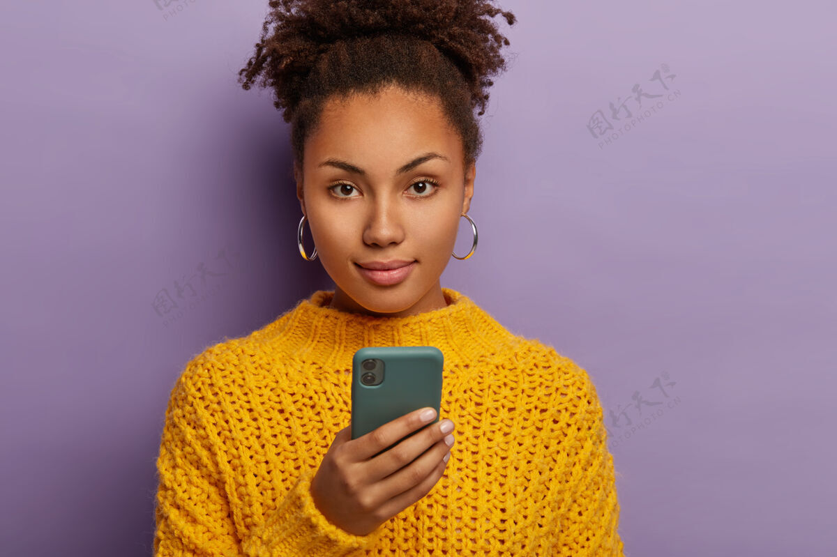 卷发一头卷曲黑发的千禧一代正经女人偷拍 用手机 直视镜头 穿黄色衣服打字毛衣美国
