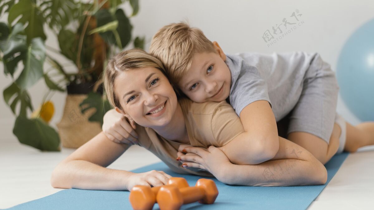 锻炼中枪的女人和孩子在瑜伽垫上私人教练垫子健康