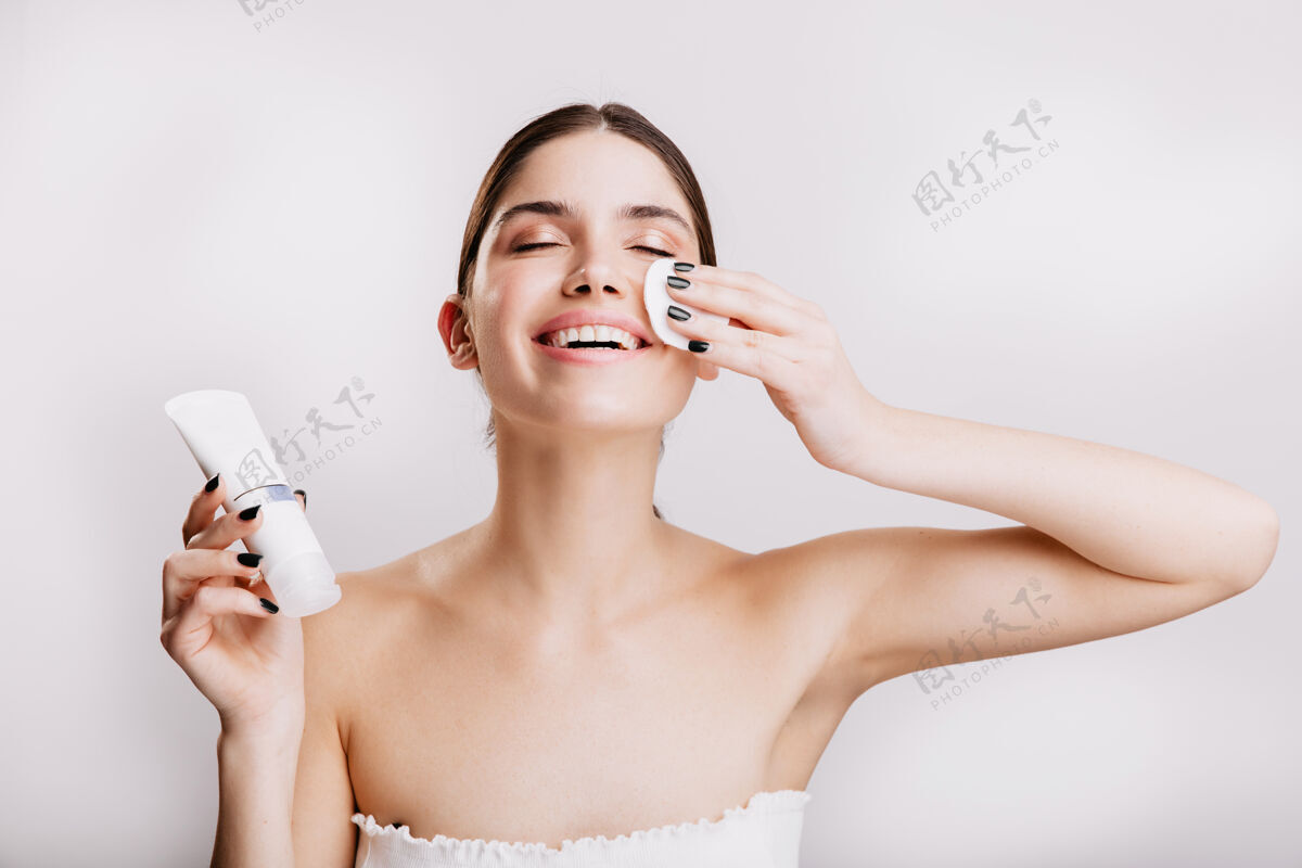模特快乐女人享受面部spa模特在涂面霜前用海绵清洁面部年轻成人保湿霜