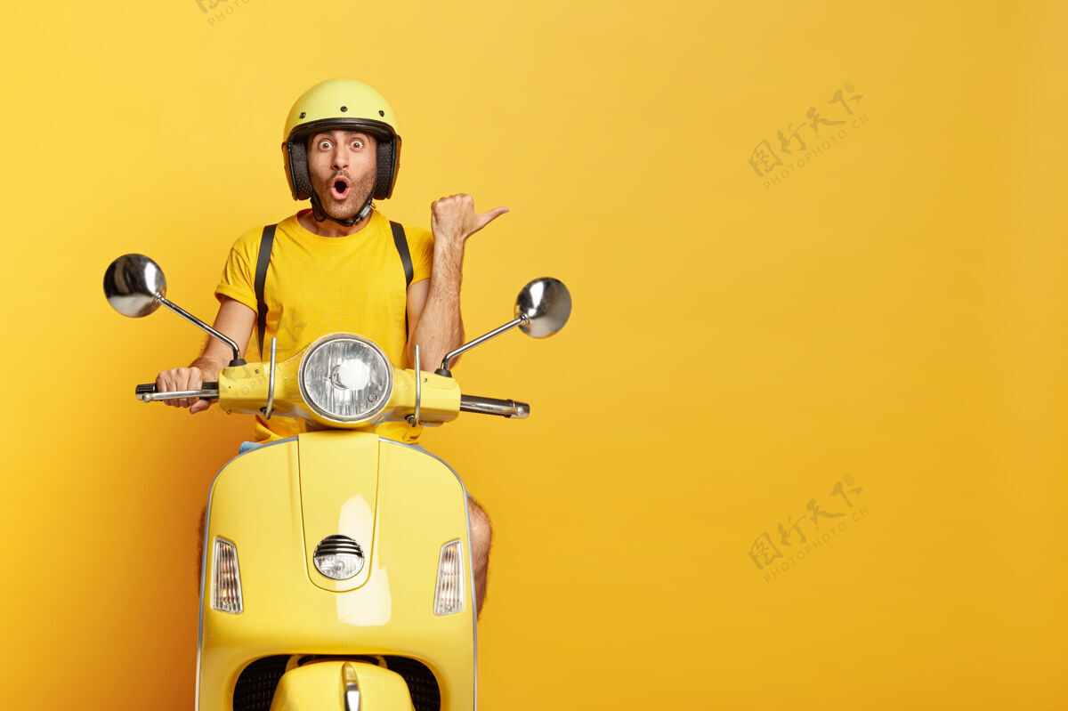 快速戴头盔的家伙开着黄色踏板车印象人目的地