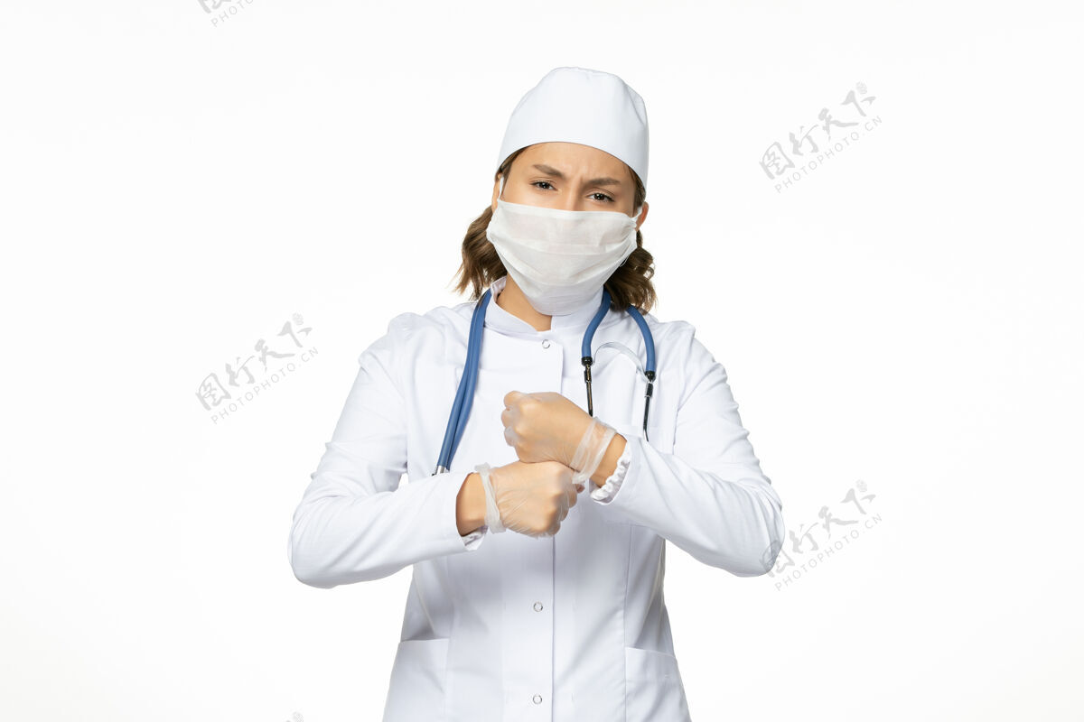 听诊器正面图年轻女医生戴着无菌口罩和防护手套 白色地板上有冠状病毒冠状病毒疾病医疗