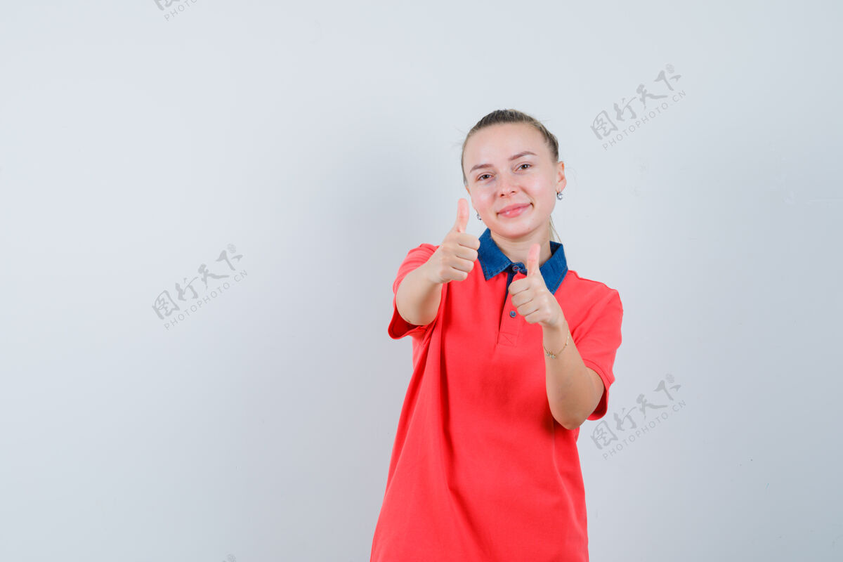 可爱一个穿着t恤的年轻女人向上竖起大拇指 看上去很快乐肖像脸双人