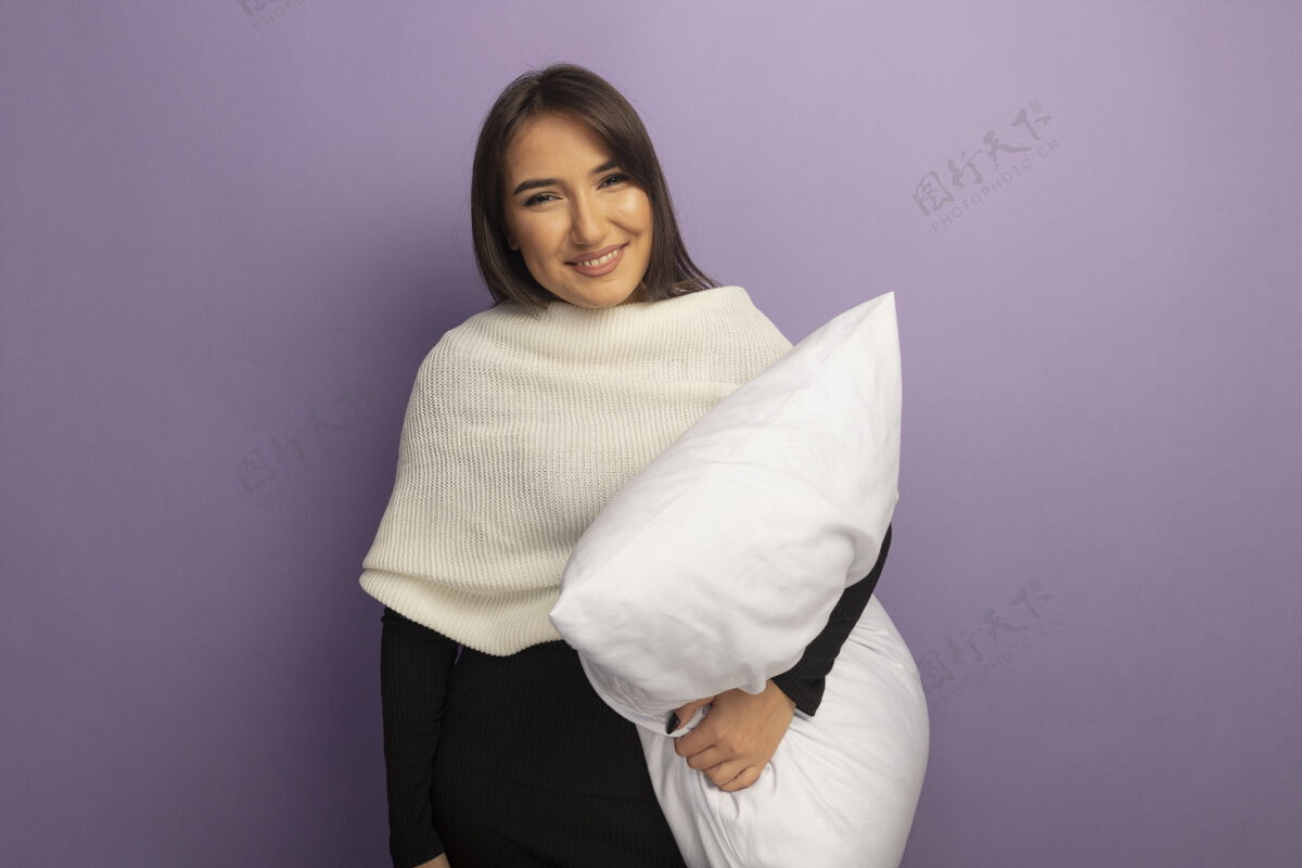 微笑年轻女子抱着枕头面带微笑紫色枕头站着