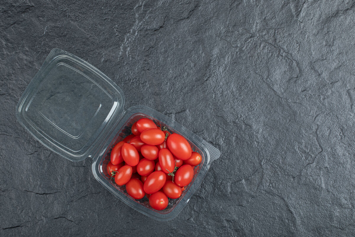 集团红色的小西红柿在塑料容器中 黑色背景高质量的照片健康番茄自然