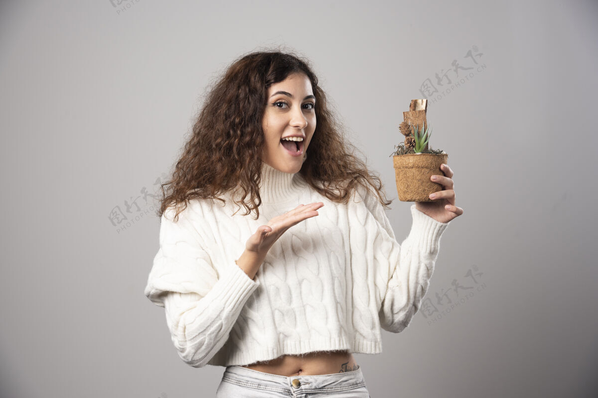 女性年轻女子拿着一株植物 指着它高质量的照片年轻人自然