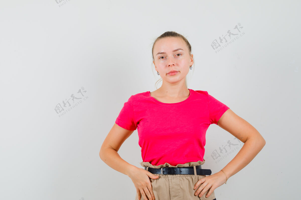 人穿着t恤 裤子的年轻女性站着摆姿势 看起来很迷人 正面视图时尚黑发年轻
