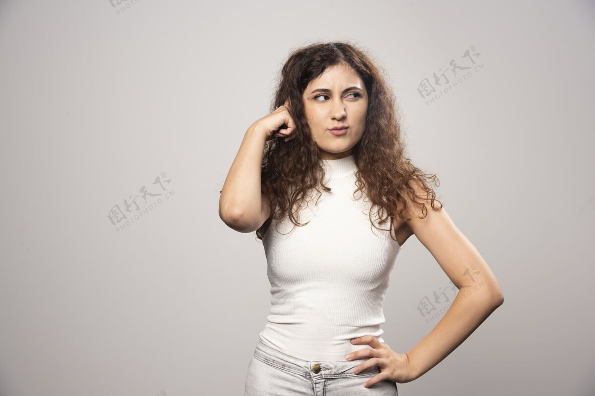 肖像穿着白色上衣的年轻女子站在白色的墙上高质量的照片年轻青少年人