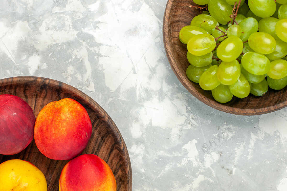 水果顶视图新鲜的绿色葡萄醇香可口 桃子放在浅白的桌子上桃子柑橘维生素