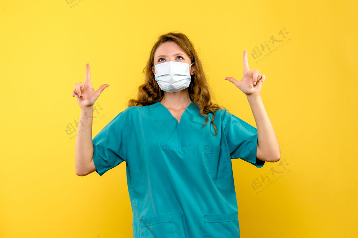 男人正面图黄色地板上戴着面罩的女医生医疗卫生大流行正面人面具