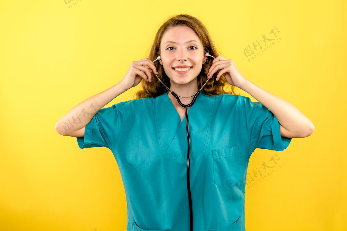 女士前视图黄色空间上带听诊器的女医生站成人大流行