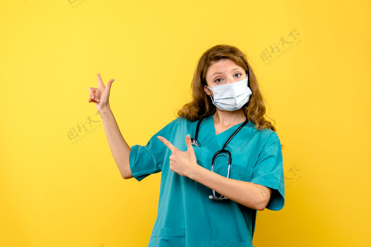 护理黄色空间里戴着面具的女医生的正视图正面女医生健康