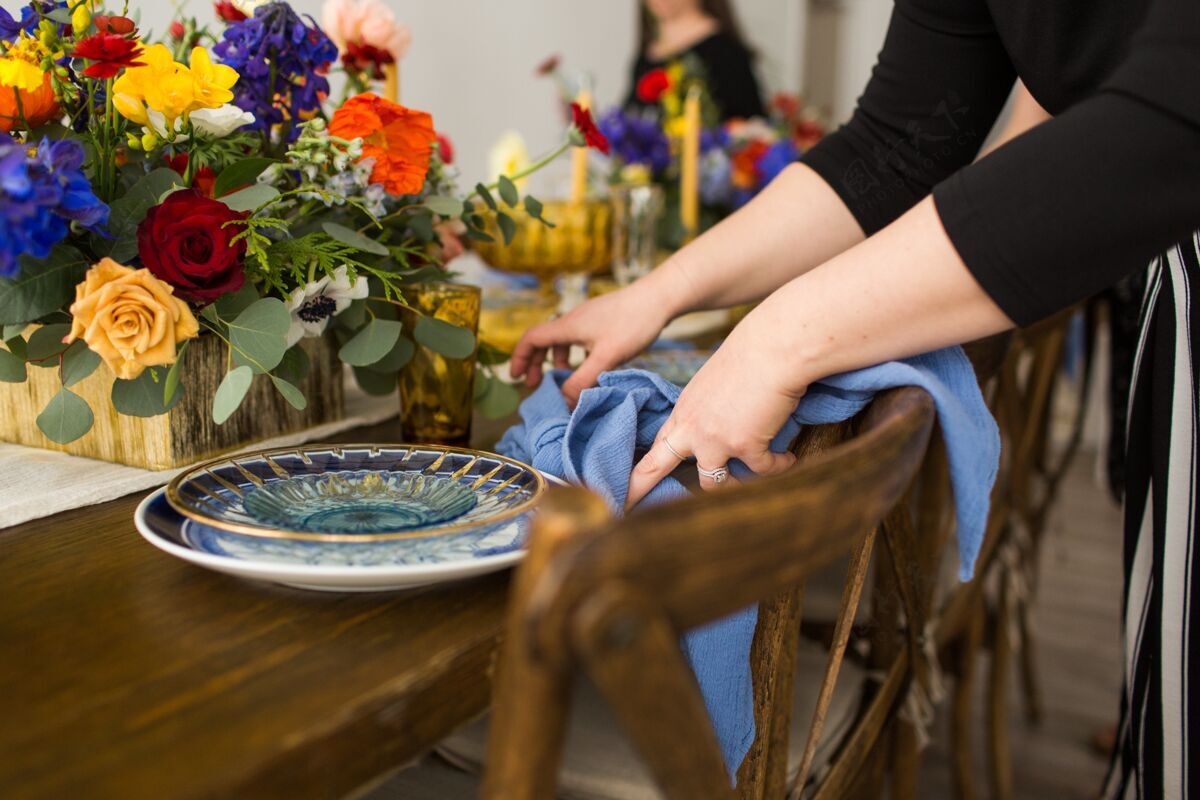 菜特写镜头一个女人穿着黑色衬衫折叠蓝色餐巾的桌子盘子聚会吃