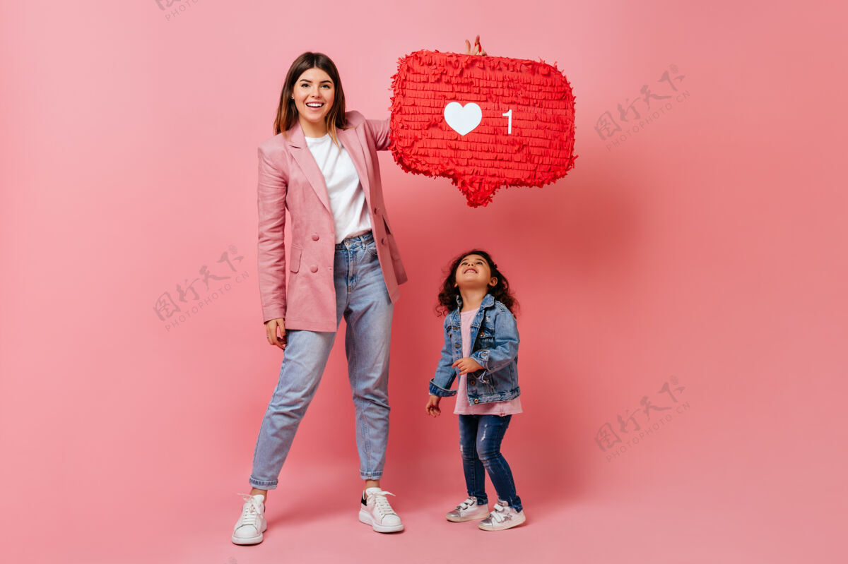 父母抱着孩子的女人举着社交网络图标摄影棚拍摄的母亲和孩子摆出像符号一样的姿势反馈互联网未成年