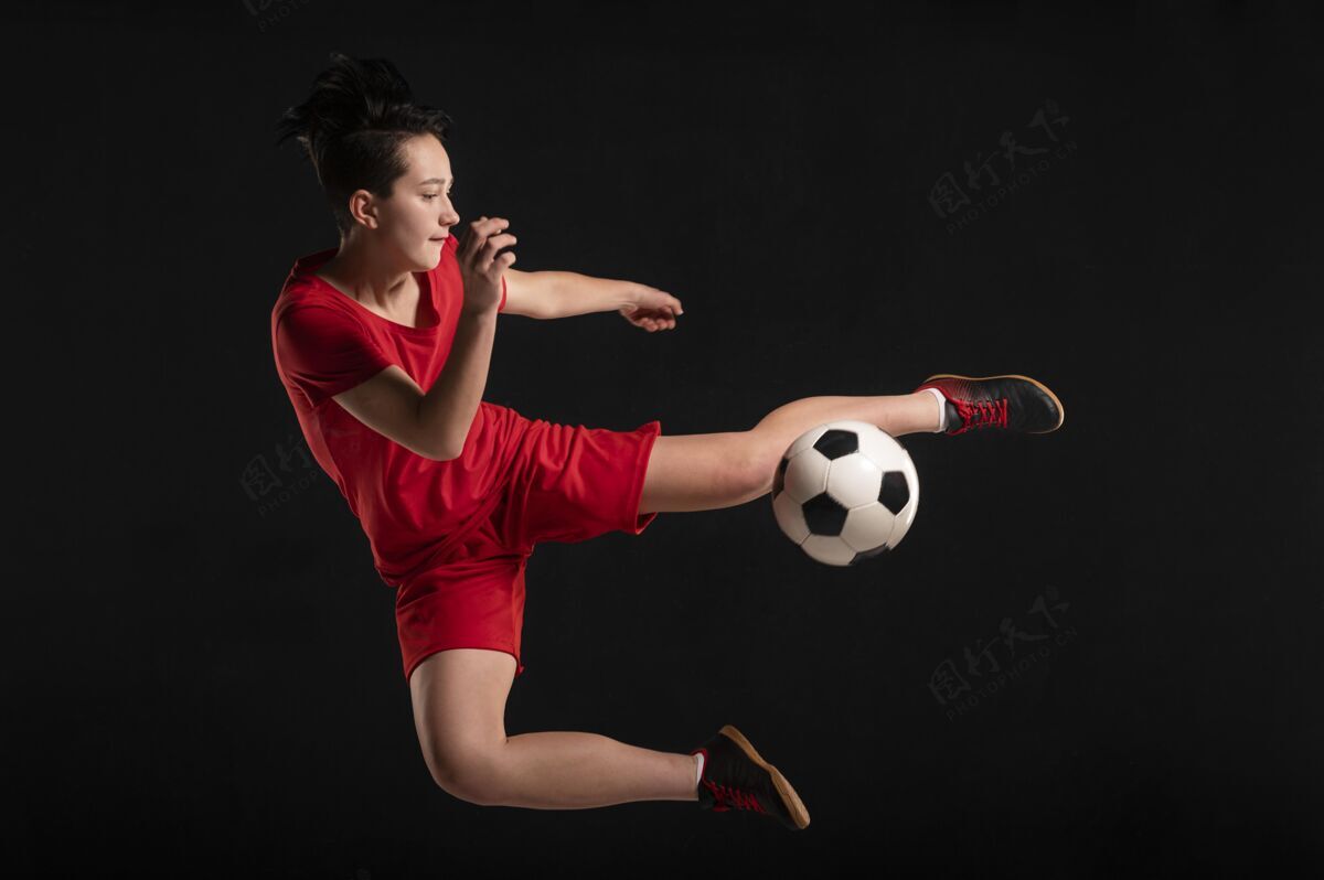 年轻女运动员跳球和踢球足球运动员女子足球