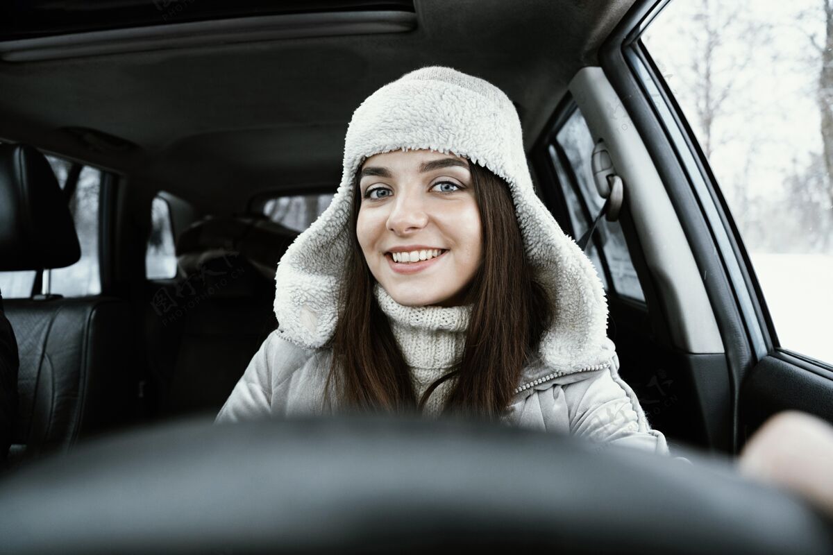 户外一个微笑的女人在公路旅行中驾驶汽车的前视图自然汽车冒险