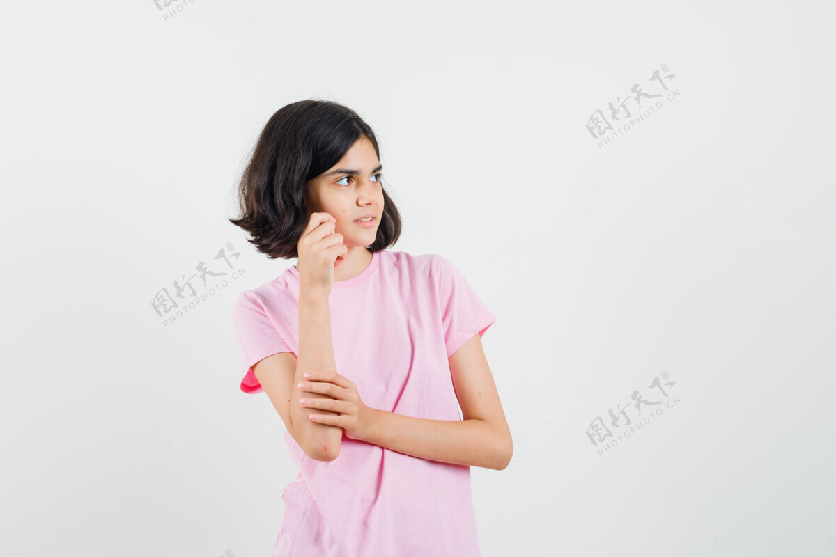外观小女孩摆姿势 一边看着旁边的粉红色t恤 看起来乐观 正面视图人美丽女孩