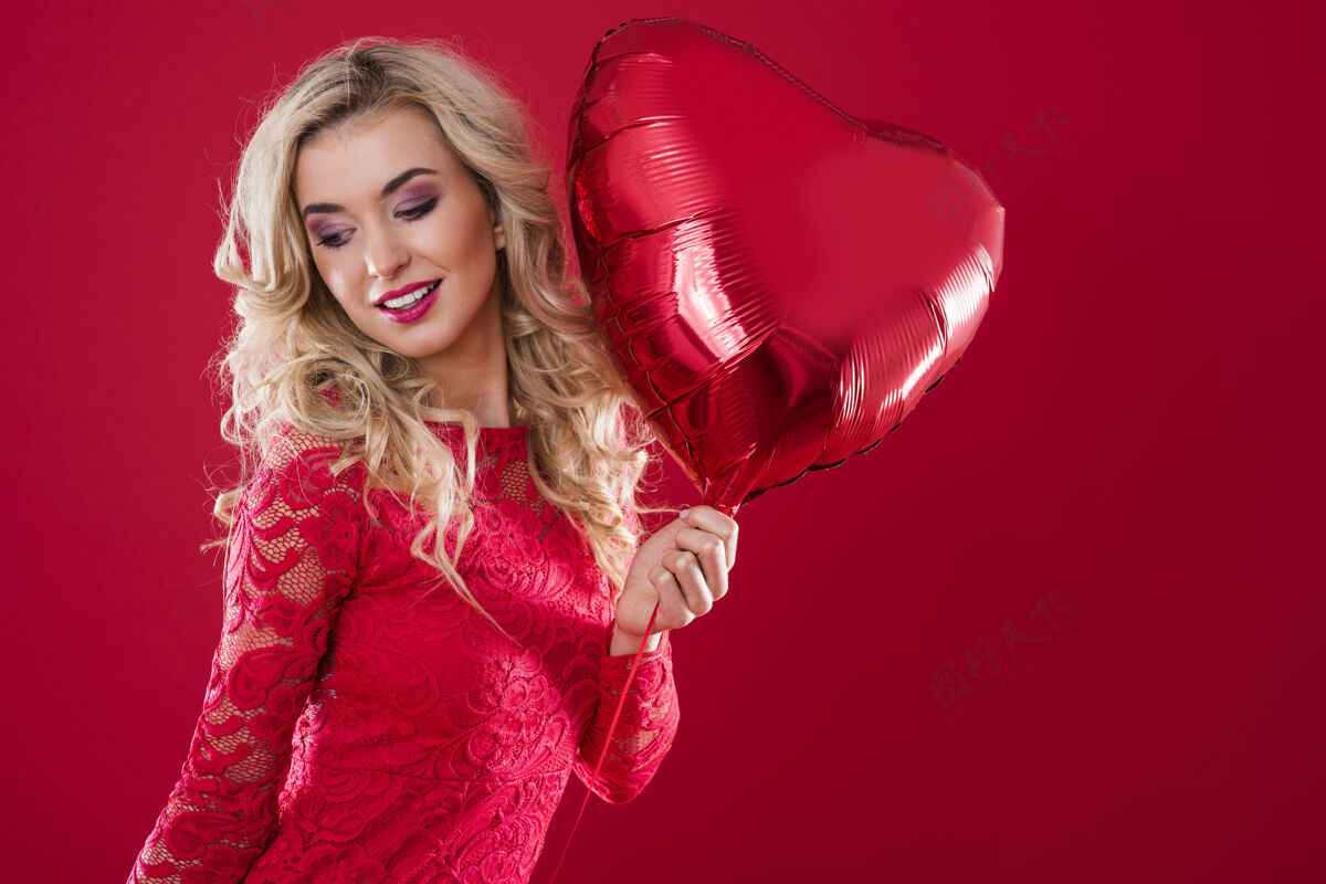 零件快乐的女人手里拿着一个大大的红色心形气球优雅连衣裙蕾丝