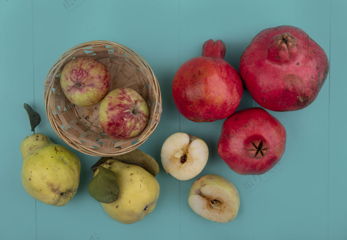 新鲜一桶新鲜苹果的俯视图 石榴和木瓜被隔离在蓝色背景上木瓜桶食物