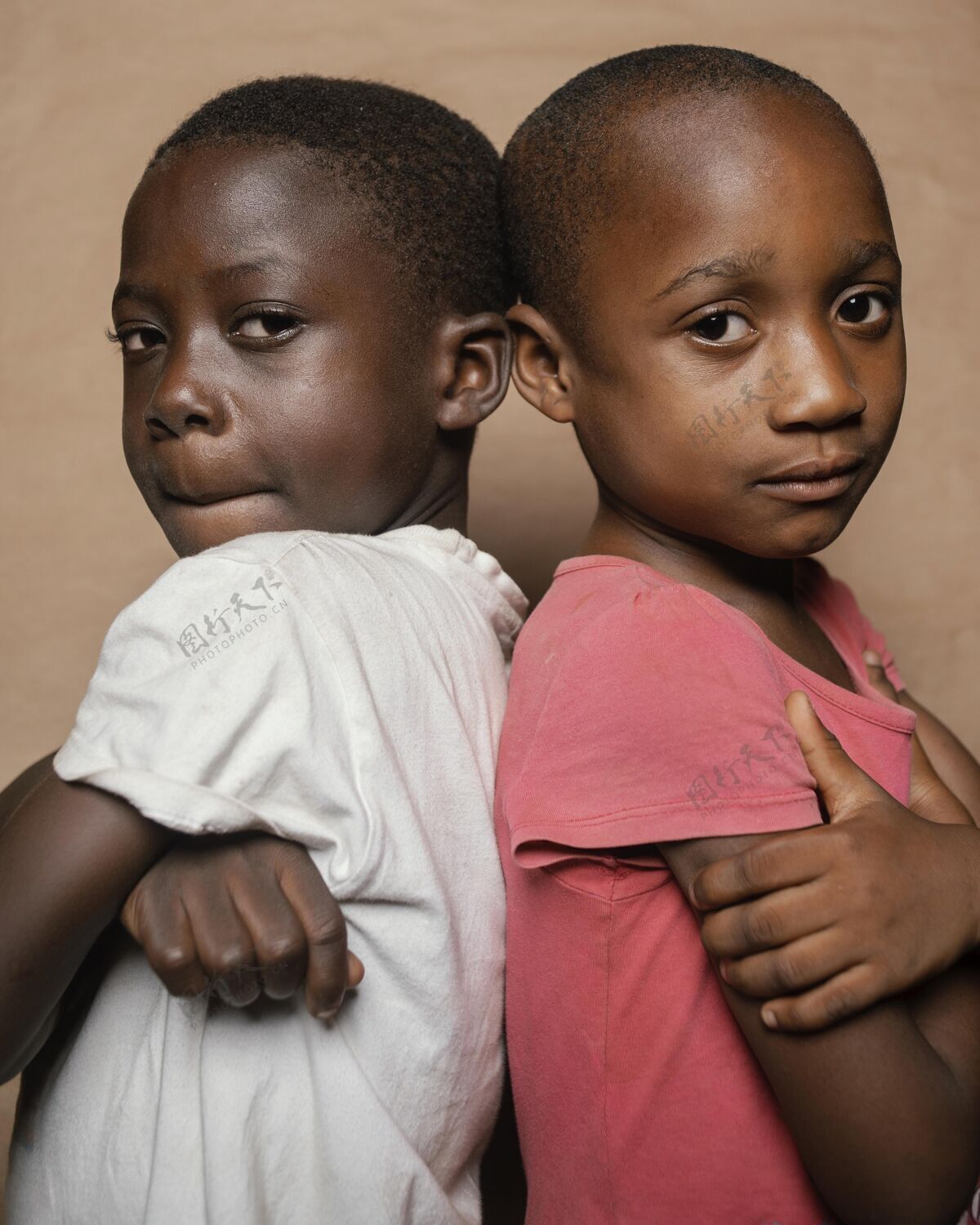 非洲人年轻的兄弟姐妹背靠背站着回来肖像女孩
