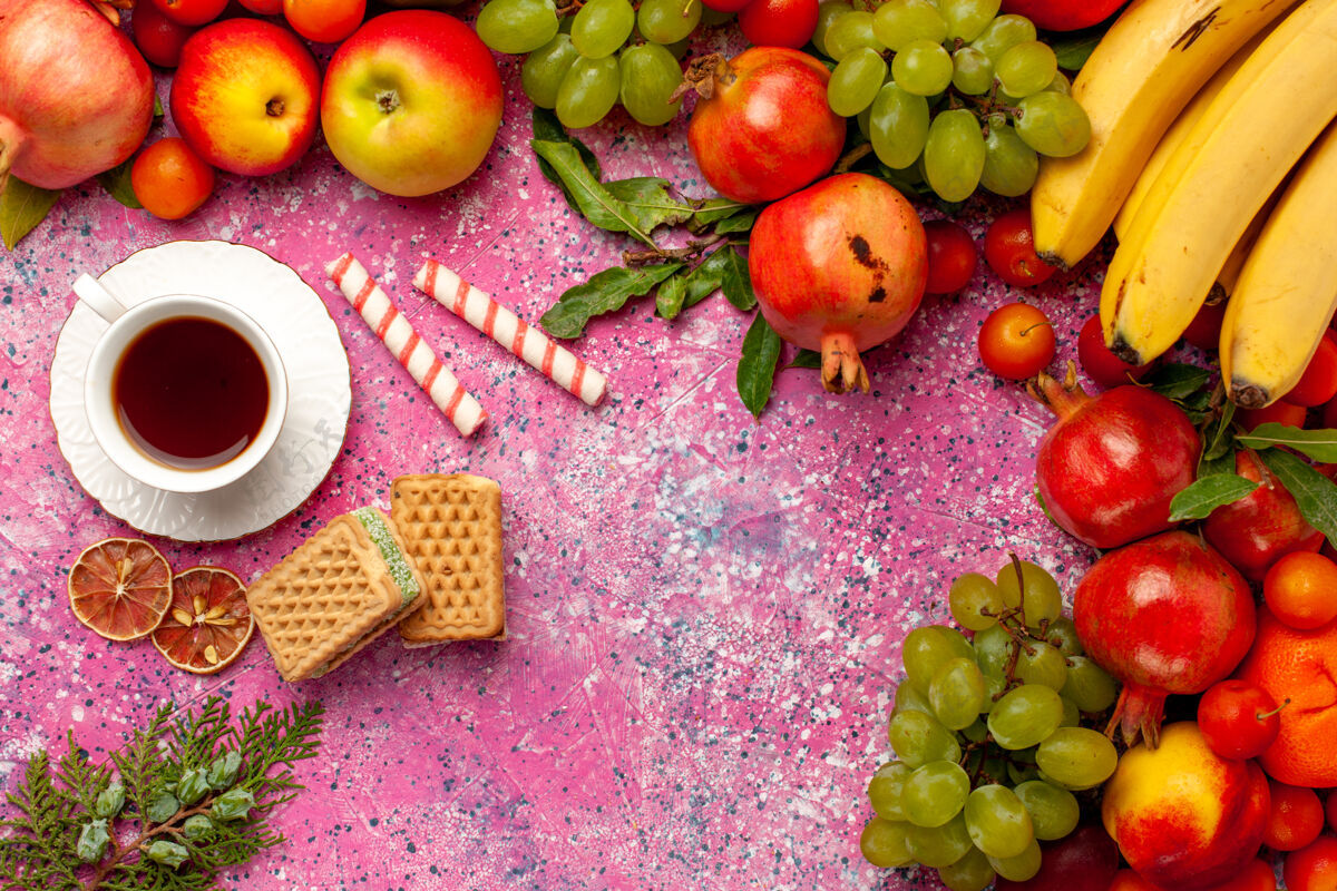 饮食顶视图新鲜水果组成五颜六色的水果与茶和华夫饼在粉红色的表面顶级醇香的柑橘