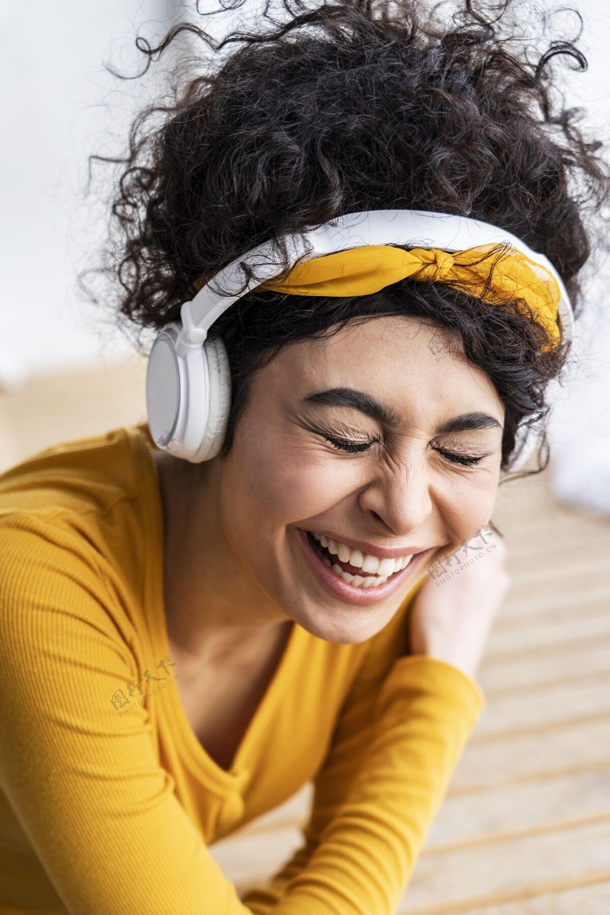 庆祝快乐的女人用耳机听音乐快乐微笑乐观