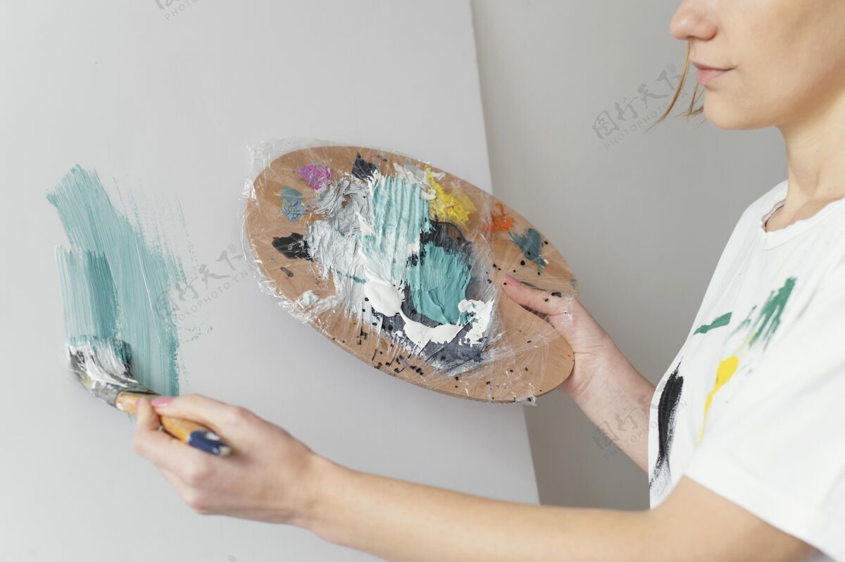 放松美丽的女人在画布上用丙烯酸树脂绘画房子女性室内