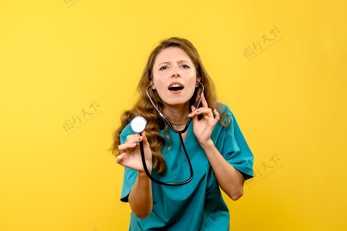 医学前视图女医生在黄色空间使用听诊器健康情绪女医生