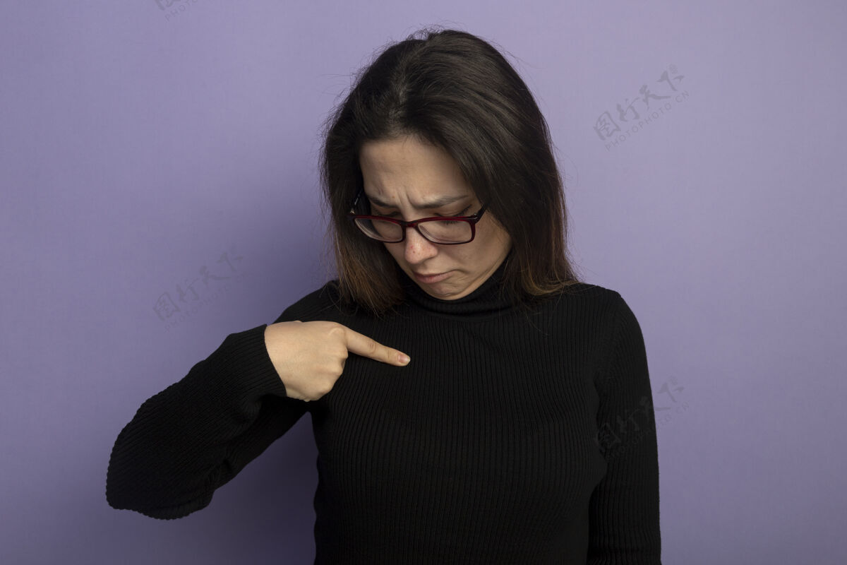 人类一个穿着黑色高领毛衣戴着眼镜的年轻漂亮女人站在紫色的墙上 用食指指着自己困惑的样子紫色女孩困惑