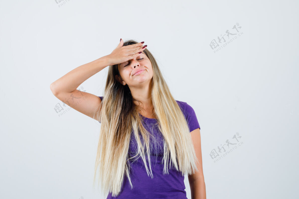 累身穿紫罗兰色t恤的金发女人 手放在额头上 看起来很累 正面照时尚年轻手