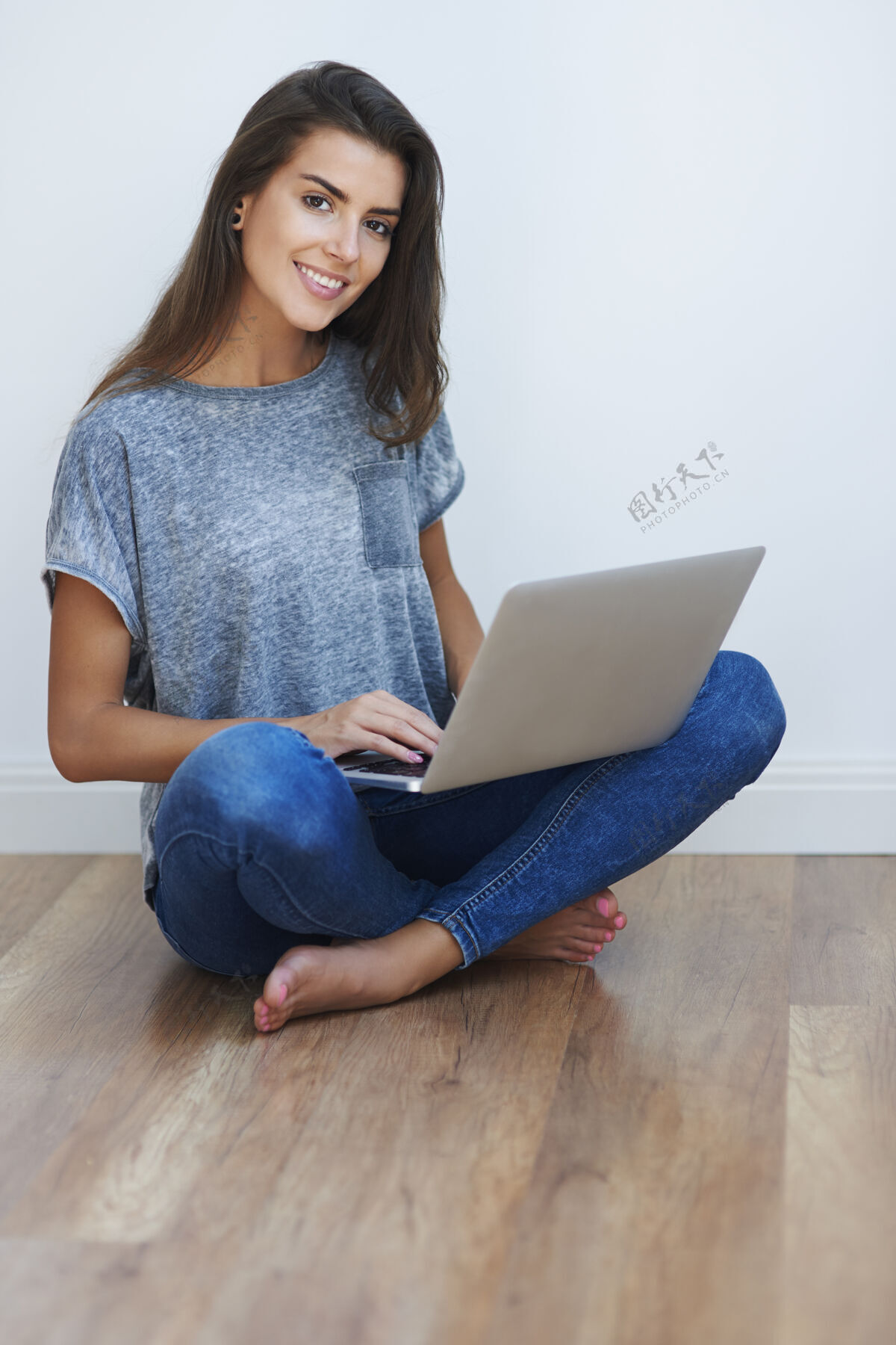笔记本电脑快乐的女孩在网上冲浪赤脚女性化长发