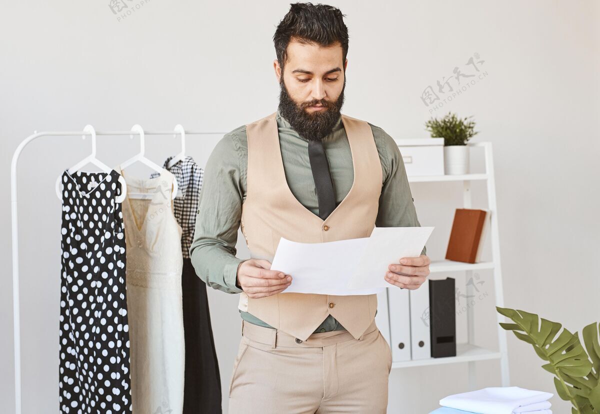 服装前视图的男性时装设计师与文件在工作室工作服装Couturier男性