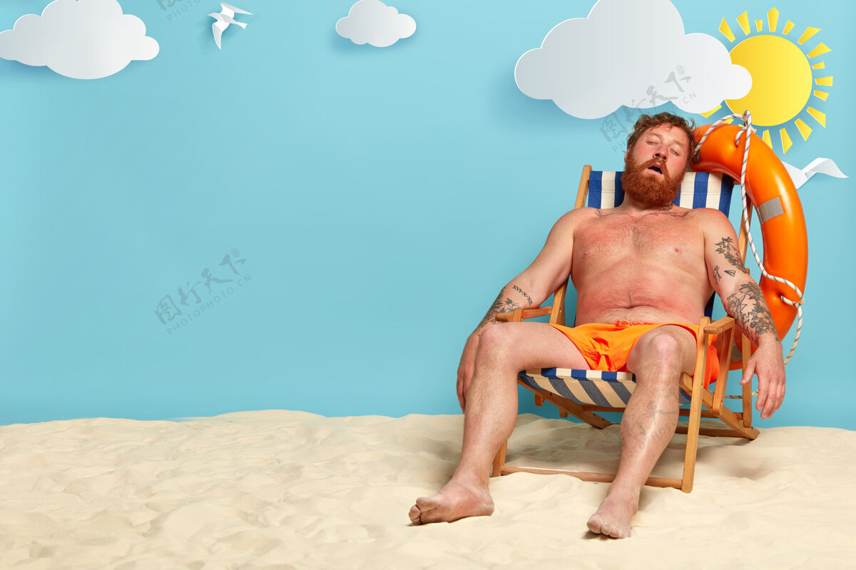 睡眠放松的大胡子男人睡在躺椅上 在沙滩上摆姿势放松姜泳装