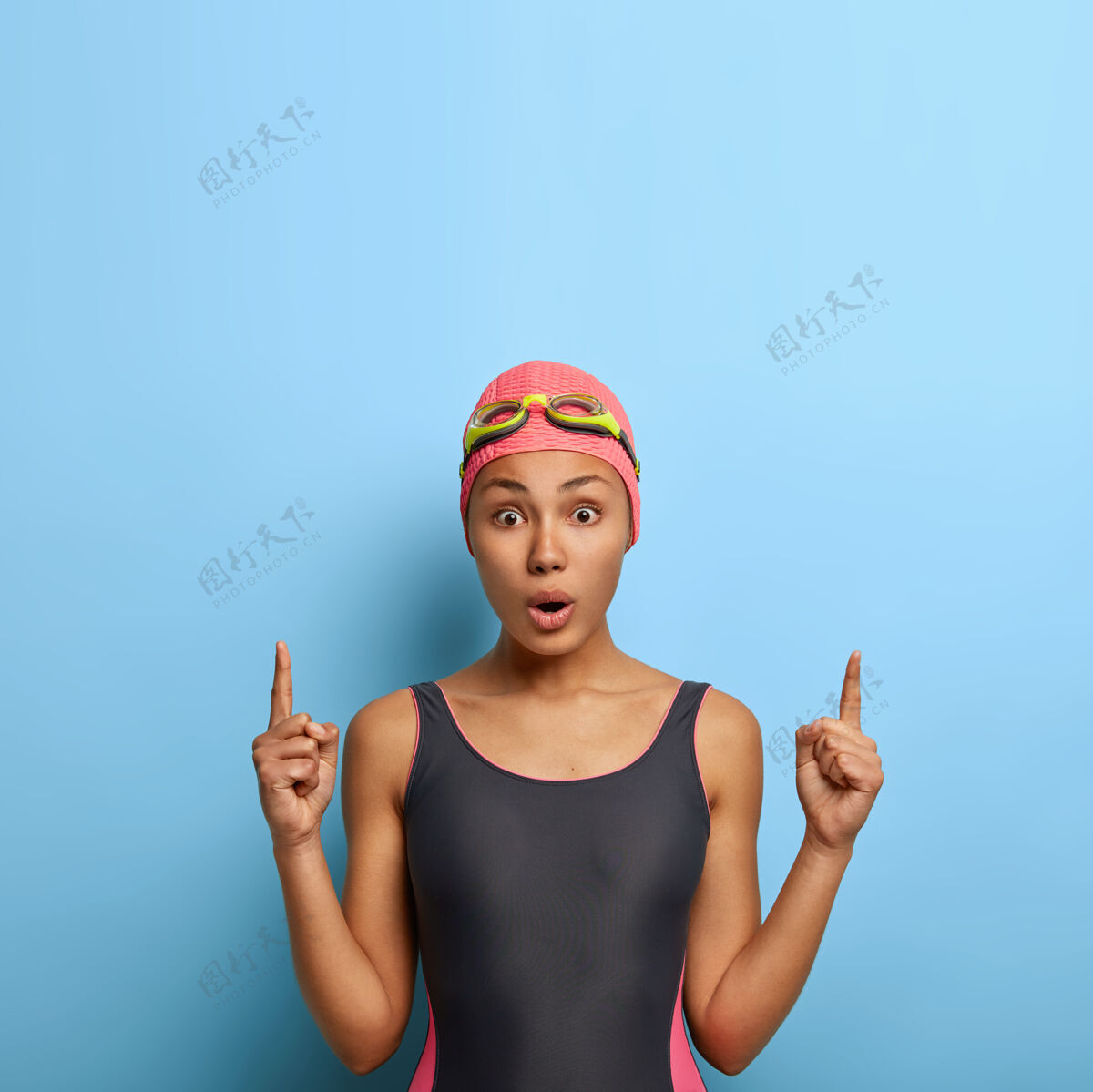 游泳水上健身概念美丽的运动游泳女孩点以上与震惊的表情泳装装备放松