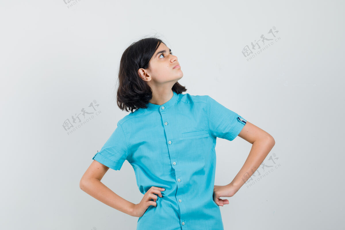 青少年穿蓝色衬衫的少女 双手放在腰上 看起来很专注表情外观手