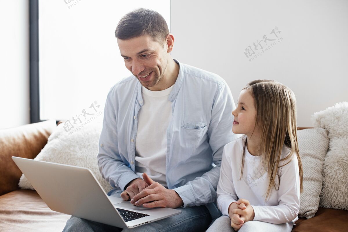 世界各地小女孩和她爸爸花时间在笔记本电脑上女孩庆祝父母