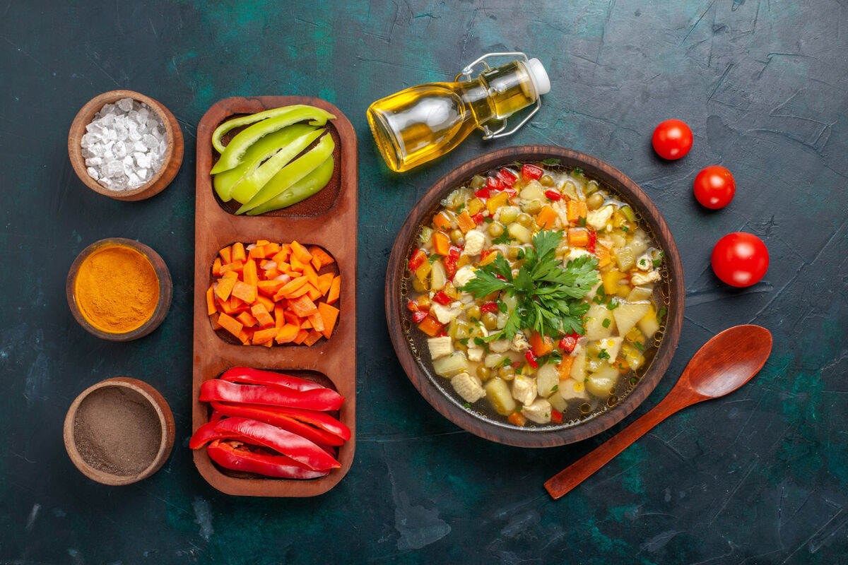 生的俯瞰美味的蔬菜汤 用不同的配料和调味料放在黑暗的桌子上 汤蔬菜酱食物热食一餐餐顶部酱汁