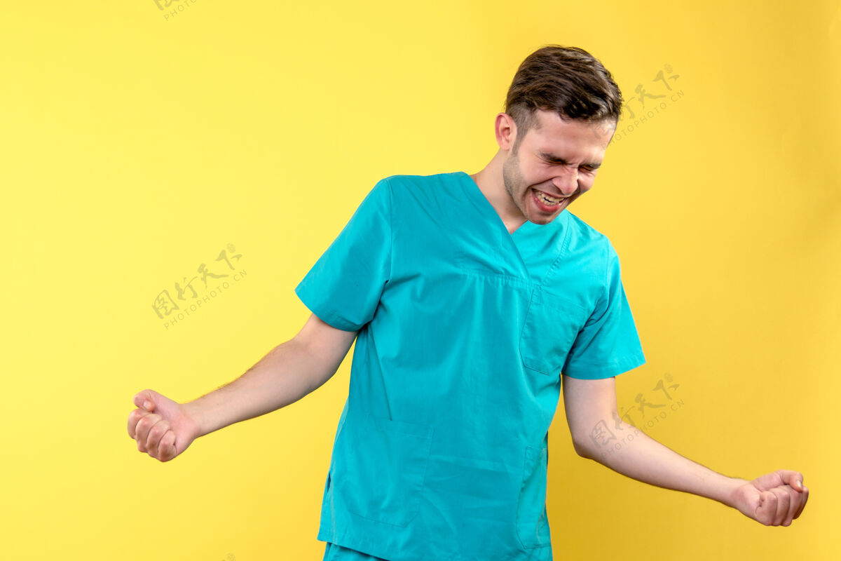 模特男医生在黄色墙上欢呼雀跃的正面图欢喜医疗快乐