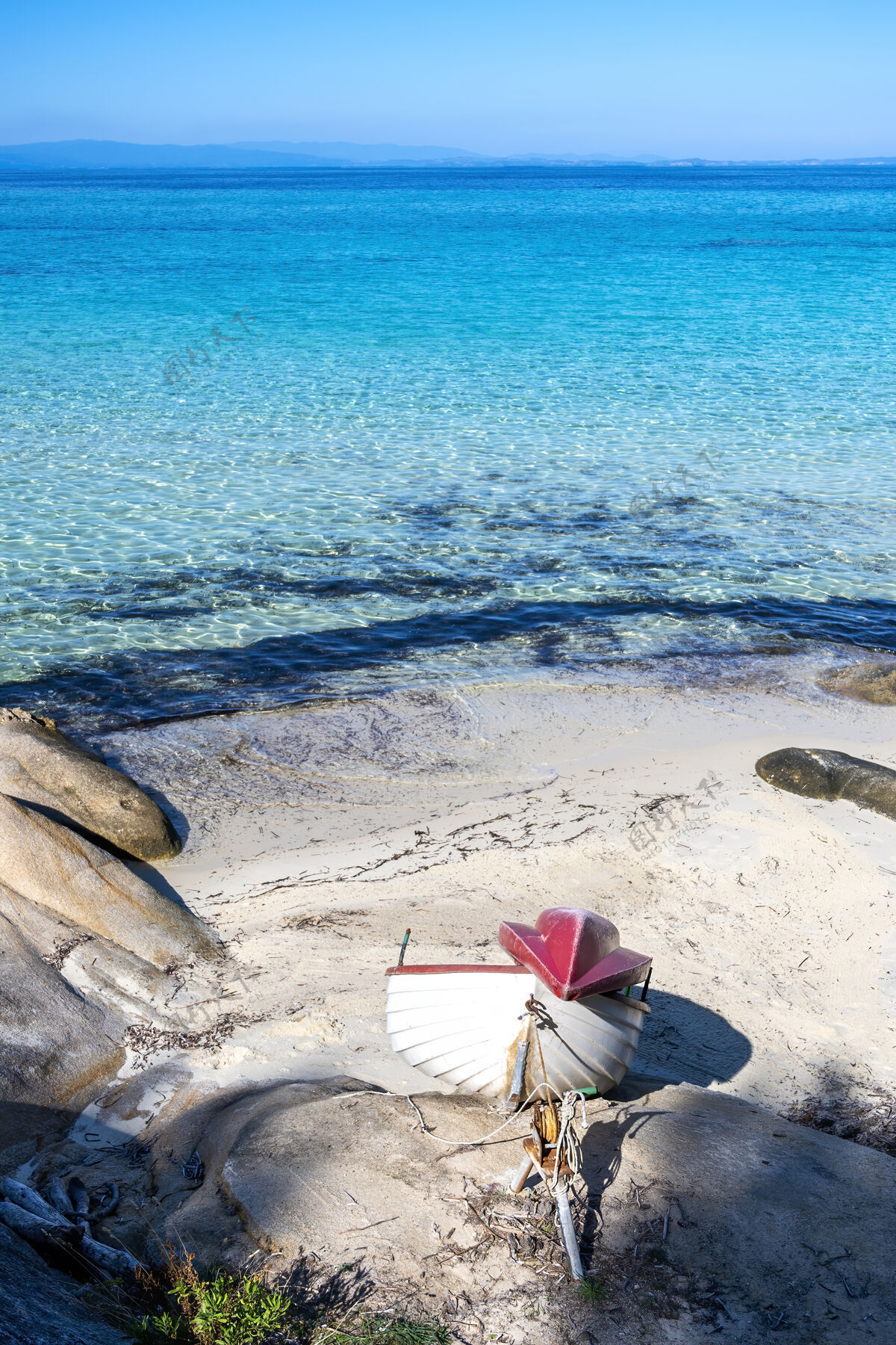 希腊爱琴海沿岸有搁浅的小船 海滩上有岩石 蓝色的海水 希腊海岸观点海