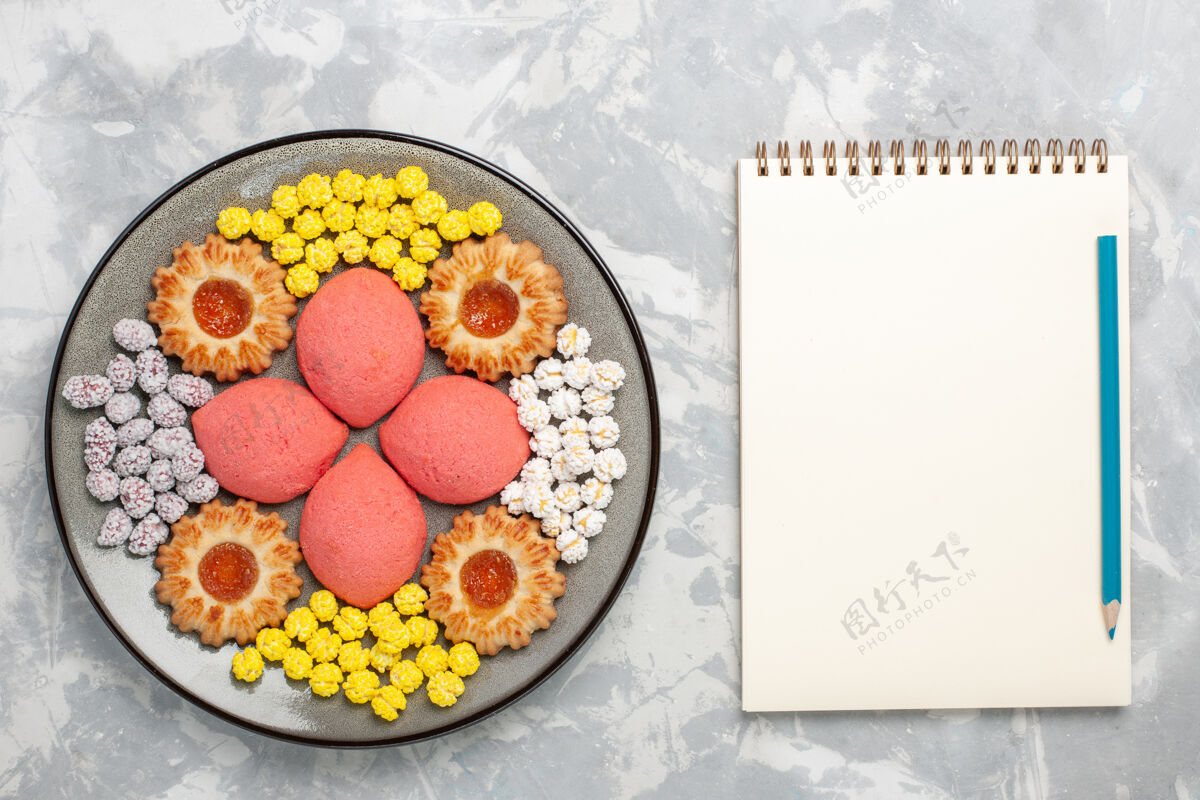 视图顶视图粉红色蛋糕与糖果和饼干在盘子里白色背景甜烤蛋糕饼干茶派饼干甜点水果茶