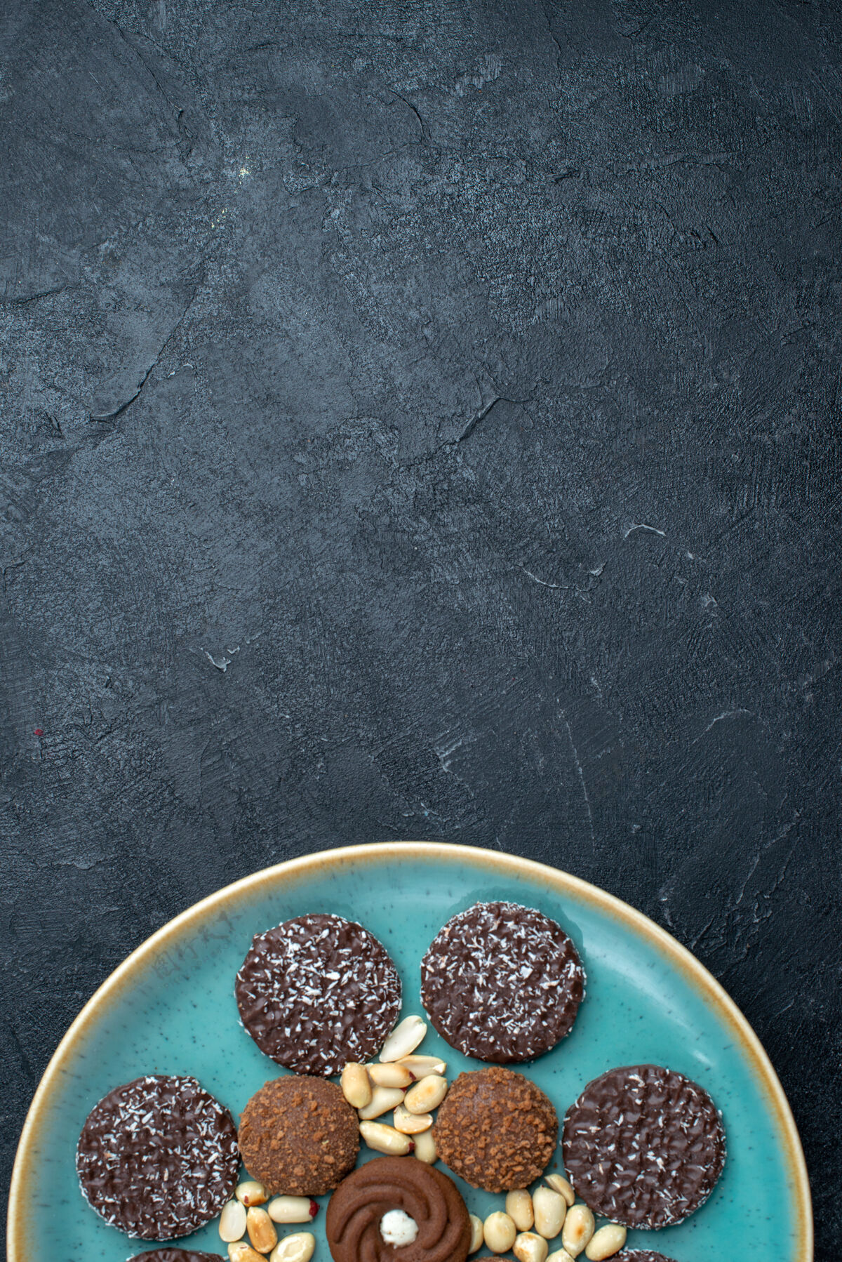 可食用的水果顶视图不同的巧克力饼干与坚果在深灰色背景糖饼干甜蛋糕派饼干黑樱桃坚果新鲜